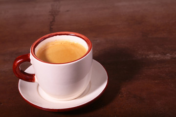A cup of espresso coffee on a dark wooden background