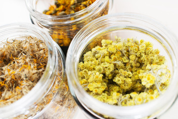 Differet dry health herbs and flowers in glasses