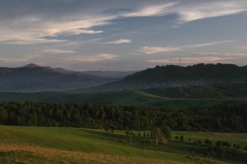 Green mountain landscape with illuminated sunset light valley and hills