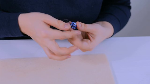 Professional jewelry designer making handmade eardrop with beads in studio, workshop. Fashion, creativity and handmade concept