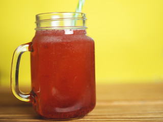 Red Morse in a glass jar on a yellow background
