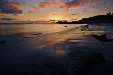 Isle of Skye, Scotland - Sandy beach at dawn with red sunrise reflecting in the wet sand