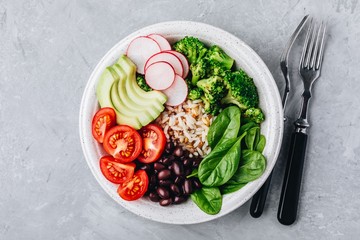 Burrito Buddha Bowl with wild rice and broccoli, spinach, black beans, tomatoes, avocado and radish