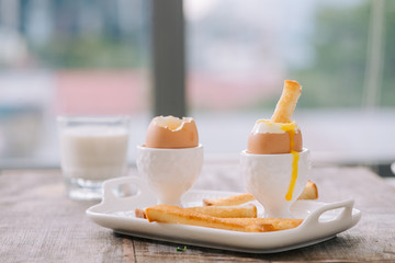 delicious breakfast with soft boiled eggs and crispy toasts, closeup