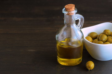 .Glass bottle of olive oil  with olive's fruit, also called the olive. It is one of the important  ingredients in Mediterranean cuisine. Copy space..
