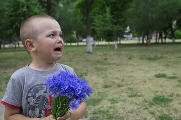 little boy crying while standing in the park