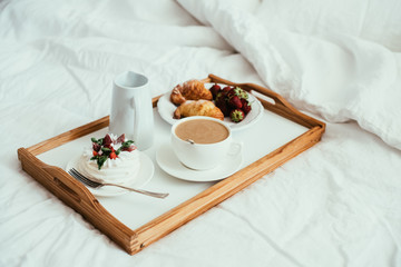 Cozy home breakfast in bed in white bedroom interior 