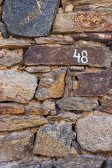 The number 48 in white paint on an old stone house wall in the village of Banya, Bulgaria