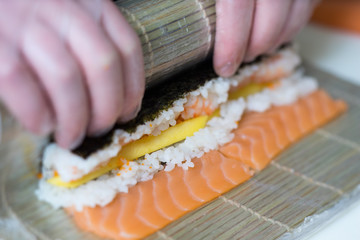 Sushi master, cutting sushi rolls. Making sushi rolls. 