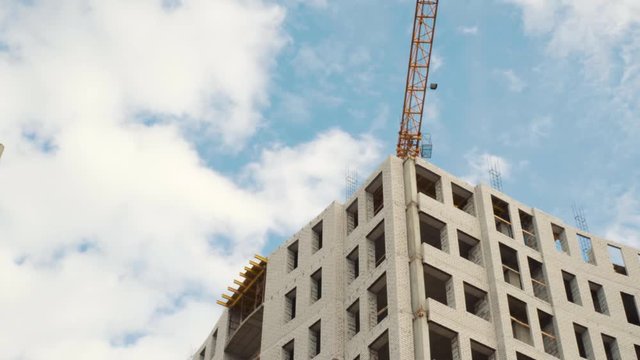Construction cranes for building on a background of blue sky with white clouds