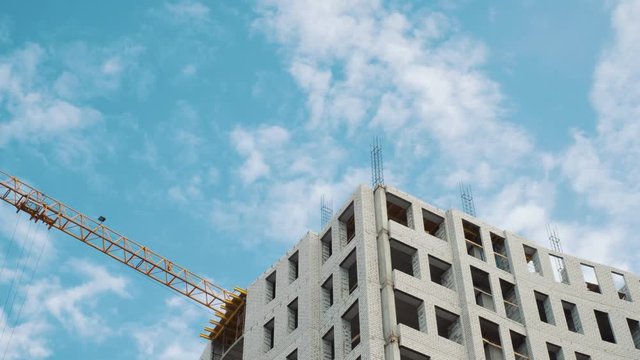 Construction cranes for building on a background of blue sky with white clouds