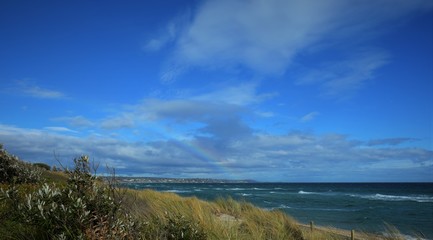 Rainbows in the sky after raining. Seaford bay beach Australia
