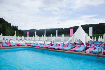 summer resort space with many loungers near swimming pool and nobody else