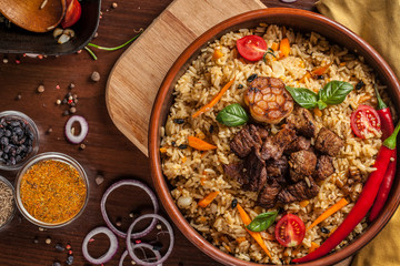 Uzbek restaurant concept, Uzbek food feast. Uzbek pilaf made from beef, lamb, chicken, in large...