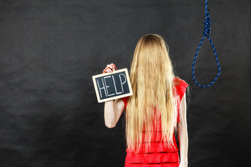 Suicidal woman holding help sign next to rope