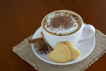 Taza de capuccino con cacao con galletas en forma de corazón
