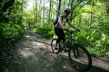 Girl on a bike riding on a forest road