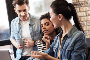 Brainstorm activity. Pleasant smart students discussing their ideas while preparing a project