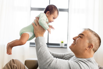 Obraz premium family, fatherhood and people concept - happy father with little baby boy sitting on sofa at home