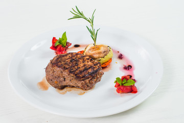 Grilled meat steak dish with fruits garnish