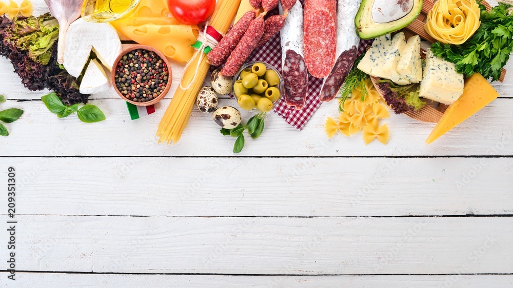 Wall mural assortment of sausage, cheese and fresh vegetables. on a white wooden background. top view. copy spa