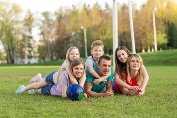 Fototapeta premium Family playing football on the field. Family football