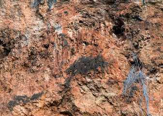 Brown clay walls rough with pattern of stains.