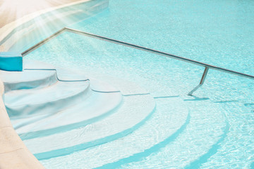 Beautifully stylish staircase steps in a swimming pool on nature sea background