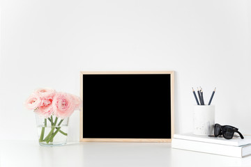 Composition with chalkboard, pink ranunculus, books and stationary. Landscape mockup