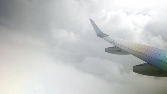 plane flying between clouds
