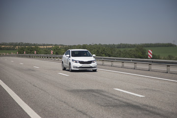 Fototapeta na wymiar White hatchback rides on the highway