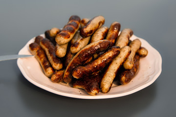 Grilled Sausages on a Plate. grey background.