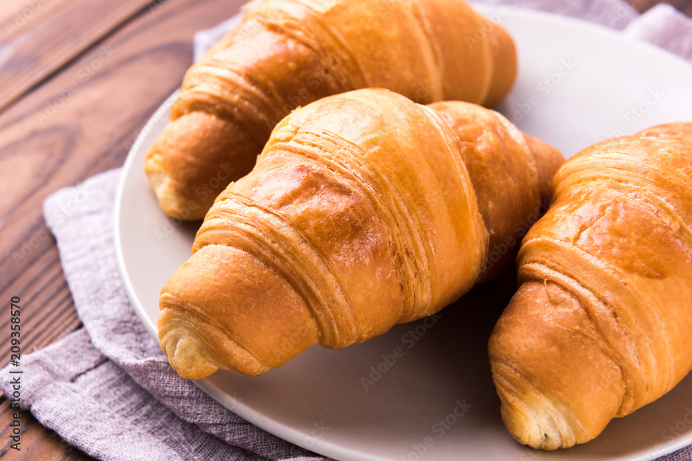 Wall mural Freshly baked butter croissant. Closeup