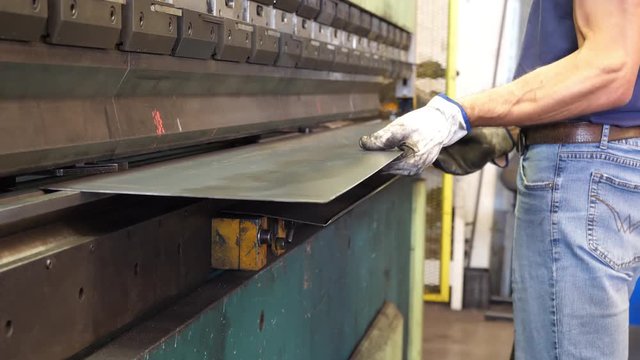 Man working a sheet metal on CNC hydraulic press brake. 4K ProRes