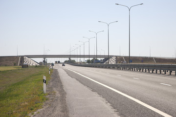 Highway to the left of the fence In a blurred background, cars are coming