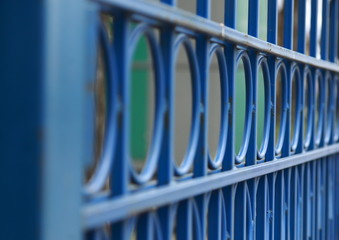 Obraz premium The welded construction of the iron gate is blue.