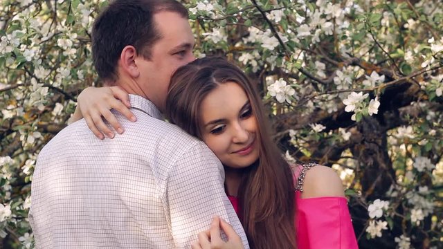 a young couple in love in the spring flowering Park