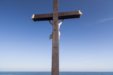  Cross with sculpture Christ crucified,mediterranean sea in maritime village of Colliuore, sotuh France.