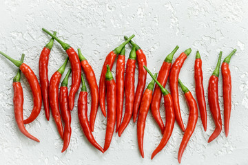 Red hot pepper pods close-up on a light background . Top view. Selective focus