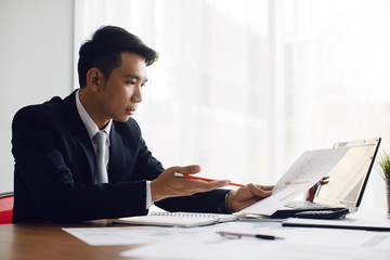 Business man working at office with laptop and documents on his desk