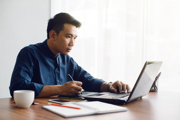 graphic designer working with laptop.creative man using pen and digital tablet at modern office.