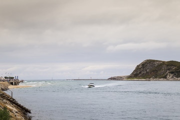 small outboard speedboat entering fast in the sea port
