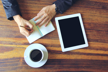 Fototapeta na wymiar Business man holding a pens and working at office with digital tablet with blank screen and coffee on the table