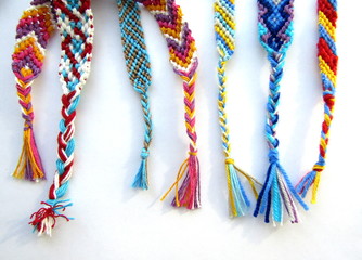 friendship bracelets made of thread with braids on white background