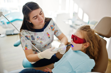 Little baby girl at dentist chair. Children dental.