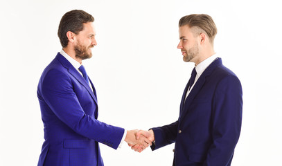 Men in suits or businessmen hold hands in handshake.