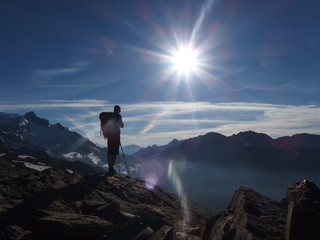 Alpy, Francja, Tour du Mont Blanc - ponad doliną Les Contamines, widok z turystą w promieniach słońca