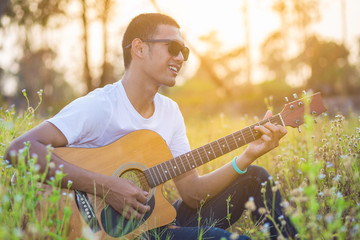 Man playing guitar on a sunny day.
