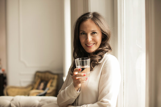 Smiling woman holding a glass of water