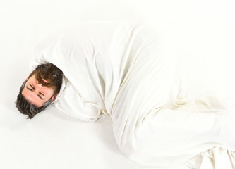 Hipster with beard fall asleep, wrapped in blanket like cocoon.